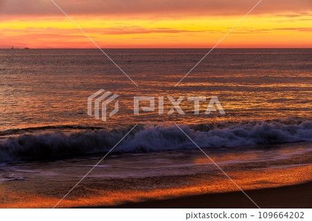 An early morning sunrise over waves ocean occurs during early hours of morning 109664202
