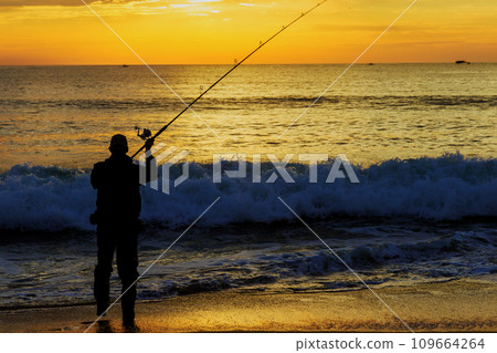 An early morning fisherman catching fish ocean at sunrise An early morning fisherman catching fish ocean at sunrise 109664264