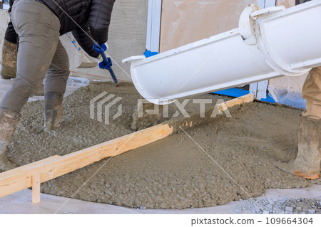 For driveway of new house, workers poured wet cement using concrete mixing truck For driveway of new house, workers poured wet cement using concrete mixing truck 109664304