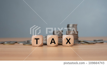 Tax wording print screen on wooden cube block and coins stacking for tax growth and planning concept, paying tax rates, collecting taxes. Tax wording print screen on wooden cube block and coins stacking for tax growth and planning concept, paying tax rates, collecting taxes. 109664743