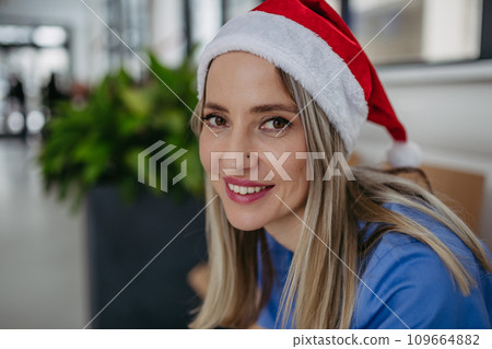 Beautiful nurse with christmas hat sitting in hospital waiting room, corridor. Obstetrics nurse working in hospital on Christmas day, Christmas Eve. Female doctor working a Christmas shift and can't Beautiful nurse with christmas hat sitting in hospital waiting room, corridor. Obstetrics nurse working in hospital on Christmas day, Christmas Eve. Female doctor working a Christmas shift and can't 109664882