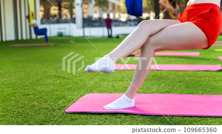 Female legs of a girl doing aerial gymnastics on fabric 109665360