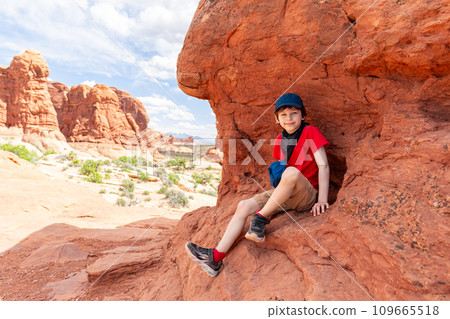 Tourist Boy Sitting on the Red Rock in Utah Tourist Boy Sitting on the Red Rock in Utah 109665518