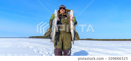 Man Holding a Fish pike in Hands. Winter fishing. Banner, copy space Man Holding a Fish pike in Hands. Winter fishing. Banner, copy space 109666325