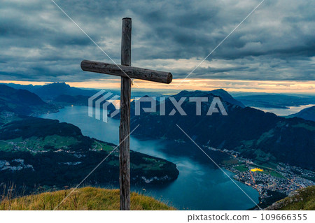 Wooden cross on summit with moody sky overlooking Lake Lucerne at Fronalpstock, Switzerland Wooden cross on summit with moody sky overlooking Lake Lucerne at Fronalpstock, Switzerland 109666355