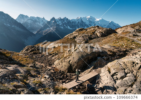 Woman with backpack hiking with Mont Blanc massif in French Alps on trail of Lac Blanc at France 109666374