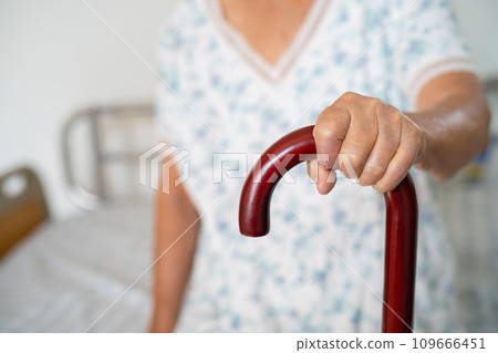 Asian elderly disability woman holding waling stick, wood cane, round handle, walking aid for help to walk. Asian elderly disability woman holding waling stick, wood cane, round handle, walking aid for help to walk. 109666451
