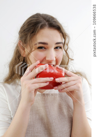 funny cheerful teen girl young woman biting red pepper healthy eating delicious food cooking salad sincerely sly look smile beautiful teeth brown hair apron kitchen close-up delicate manicure health funny cheerful teen girl young woman biting red pepper healthy eating delicious food cooking salad sincerely sly look smile beautiful teeth brown hair apron kitchen close-up delicate manicure health 109666538