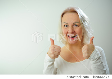 The joy of happiness of approval Plenty of space for text advertising A woman shows class She is very pleased with something And happy She raised her thumbs white background Studio blonde hair The joy of happiness of approval Plenty of space for text advertising A woman shows class She is very pleased with something And happy She raised her thumbs white background Studio blonde hair 109666573