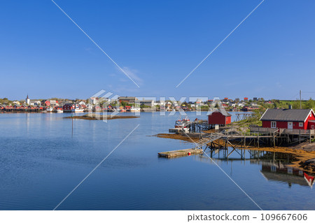 Serene Reine village view in Lofoten, Norway with red rorbu cabins, boats, and clear sky 109667606