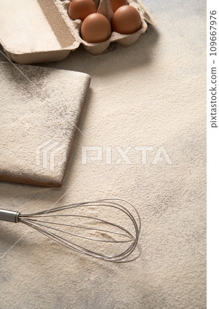 Baking background with flour, eggs and egg whisk. Vertical photo. Baking background with flour, eggs and egg whisk. Vertical photo. 109667976