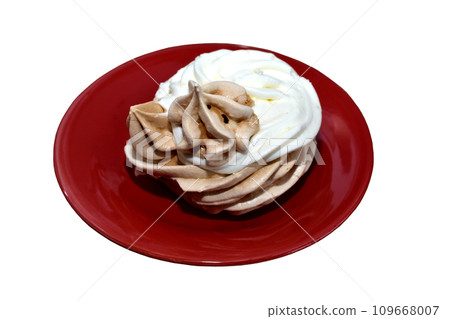 On a plate there is a meringue cake with cream on a white background. 109668007