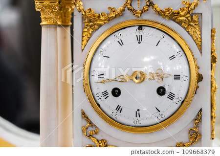 Vintage chiming mantel clock close-up photo, front view. White enamel clock face Vintage chiming mantel clock close-up photo, front view. White enamel clock face 109668379