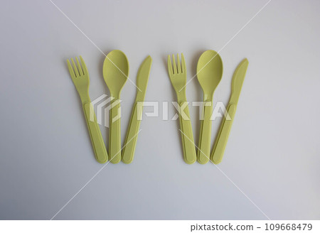 Plastic fork, spoon and olive-colored knife are on the table 109668479