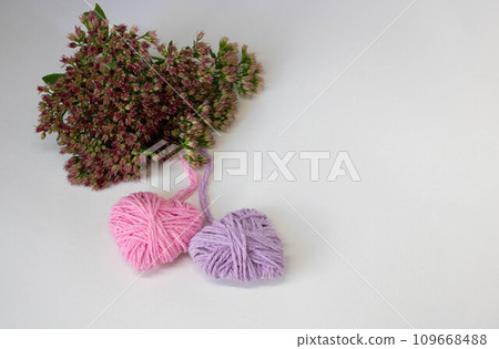 Two hearts pink and lilac on a background of pink flowers. The concept of Valentine's Day, March 8, Family Day, Mother's Day. Two hearts pink and lilac on a background of pink flowers. The concept of Valentine's Day, March 8, Family Day, Mother's Day. 109668488
