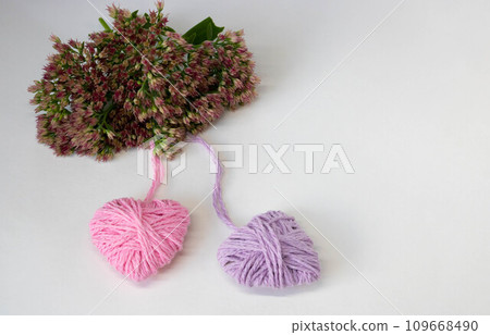 Two hearts pink and lilac on a background of pink flowers. The concept of Valentine's Day, March 8, Family Day, Mother's Day. Two hearts pink and lilac on a background of pink flowers. The concept of Valentine's Day, March 8, Family Day, Mother's Day. 109668490