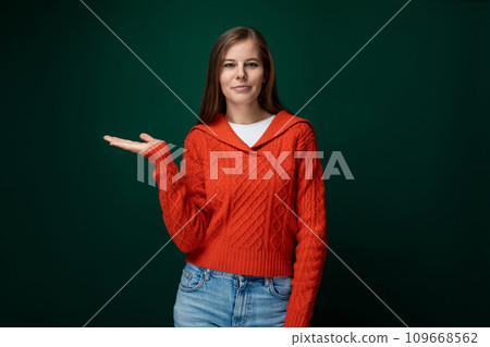 Cute young woman pointing with hand at advertising space Cute young woman pointing with hand at advertising space 109668562
