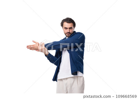 young brutal caucasian man with black hair is dressed in a blue shirt over a t-shirt 109668569