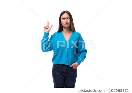 young well-groomed brunette woman dressed in a blue cardigan on a white background with copy space 109668571