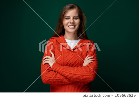 Cute young woman with brown hair wearing a red knitted sweater 109668629
