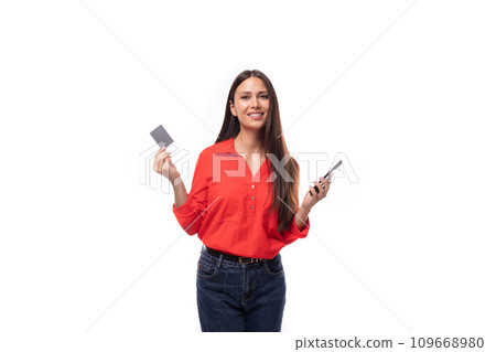 young successful brunette assistant woman dressed in a red blouse uses m-banking from a smartphone young successful brunette assistant woman dressed in a red blouse uses m-banking from a smartphone 109668980