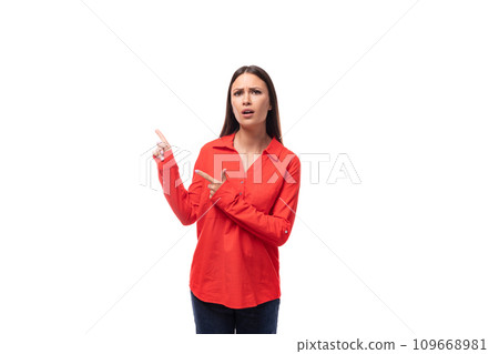 young charming brunette employee woman dressed in a red loose shirt gesturing on a white background young charming brunette employee woman dressed in a red loose shirt gesturing on a white background 109668981