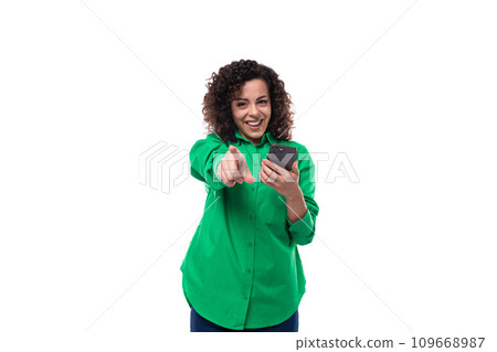 young office woman with curly hair dressed in a green shirt takes a photo on a smartphone young office woman with curly hair dressed in a green shirt takes a photo on a smartphone 109668987