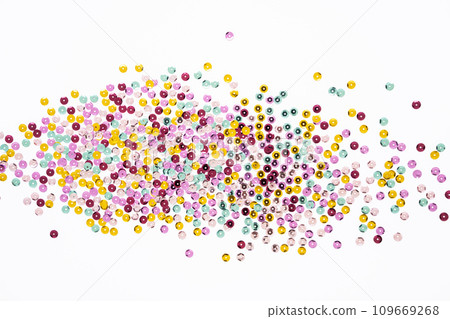 Various colored sequins on a white background. 109669268