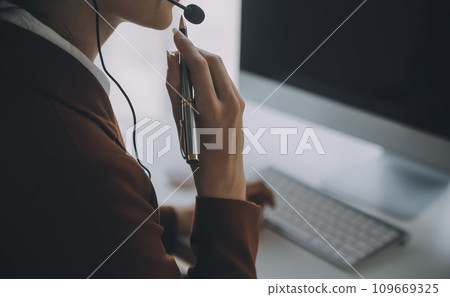 Customer service representative with curly hair talking through headset Customer service representative with curly hair talking through headset 109669325