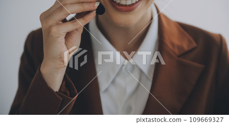 Customer service representative with curly hair talking through headset 109669327