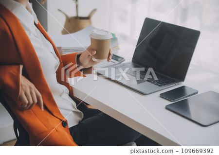 Portrait of Young Asian woman hand freelancer is working her job on computer tablet in modern office. Doing accounting analysis report real estate investment data, Financial and tax systems concept. 109669392