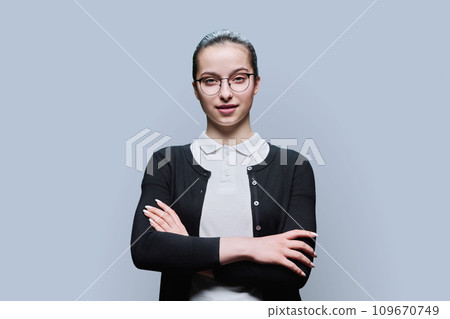 Portrait of confident smiling teenager girl on grey background Portrait of confident smiling teenager girl on grey background 109670749