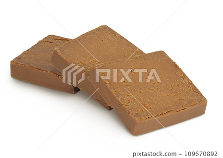 Brown cheese. Norwegian brunost isolated on white background with full depth of field Brown cheese. Norwegian brunost isolated on white background with full depth of field 109670892