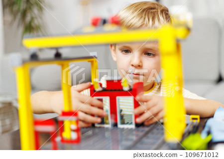 Child boy playing and building with colorful plastic bricks at the table 109671012