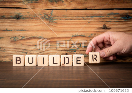 BUILDER. Alphabet blocks on wood texture background BUILDER. Alphabet blocks on wood texture background 109671623