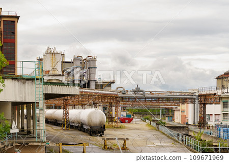At a chemical plant there are railway tanks with chemicals. 109671969