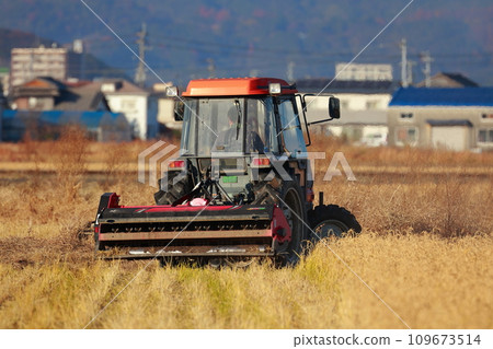 Tractor plowing a rice field in the countryside Tractor plowing a rice field in the countryside 109673514