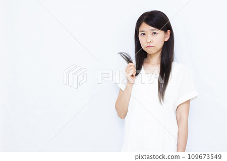 A woman in her 30s suffering from damaged hair ends 109673549