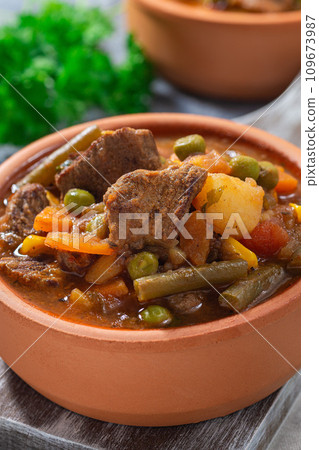 Beef stew with potato, green beans, carrot, peas and corn, in ceramic bowl, vertical, closeup Beef stew with potato, green beans, carrot, peas and corn, in ceramic bowl, vertical, closeup 109673987