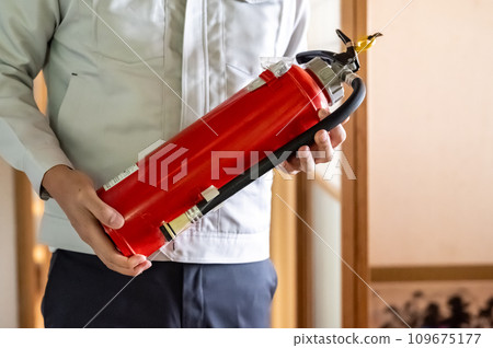 Male worker with a fire extinguisher 109675177