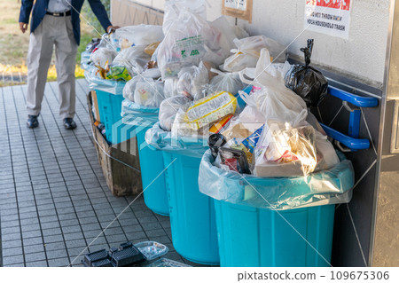Overflowing garbage collection site, man throwing away garbage Overflowing garbage collection site, man throwing away garbage 109675306