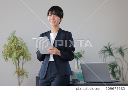 坐在辦公桌前操作平板電腦的女商人2 109675683