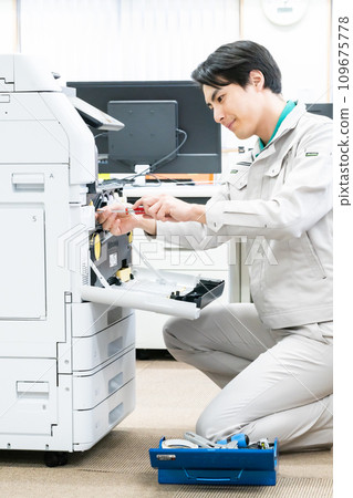Service man maintaining copy machine Service man maintaining copy machine 109675778
