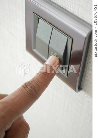 A finger turning on lighting switch . A finger turning on lighting switch . 109676451