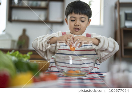 Elementary school boy breaking an egg 109677034