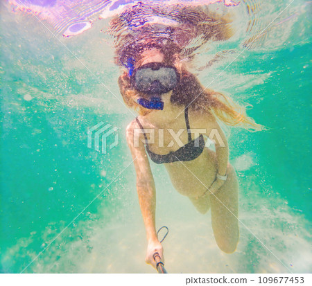 In an ethereal underwater scene, a pregnant woman gracefully floats, embodying the beauty of maternity beneath the tranquil surface of the sea In an ethereal underwater scene, a pregnant woman gracefully floats, embodying the beauty of maternity beneath the tranquil surface of the sea 109677453
