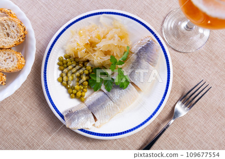 Light salted herring with marinated cabbage and green peas 109677554
