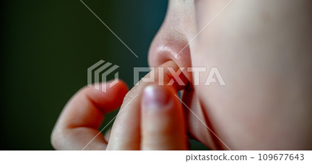 Caucasian young child picking their nose with an index finger Caucasian young child picking their nose with an index finger 109677643
