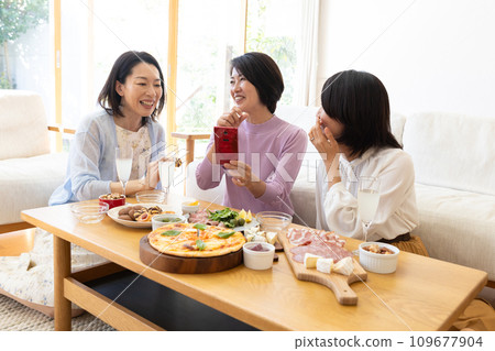 Middle-aged woman enjoying a home party 109677904