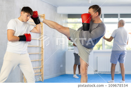 Two men training boxing and kicking in studio 109678534